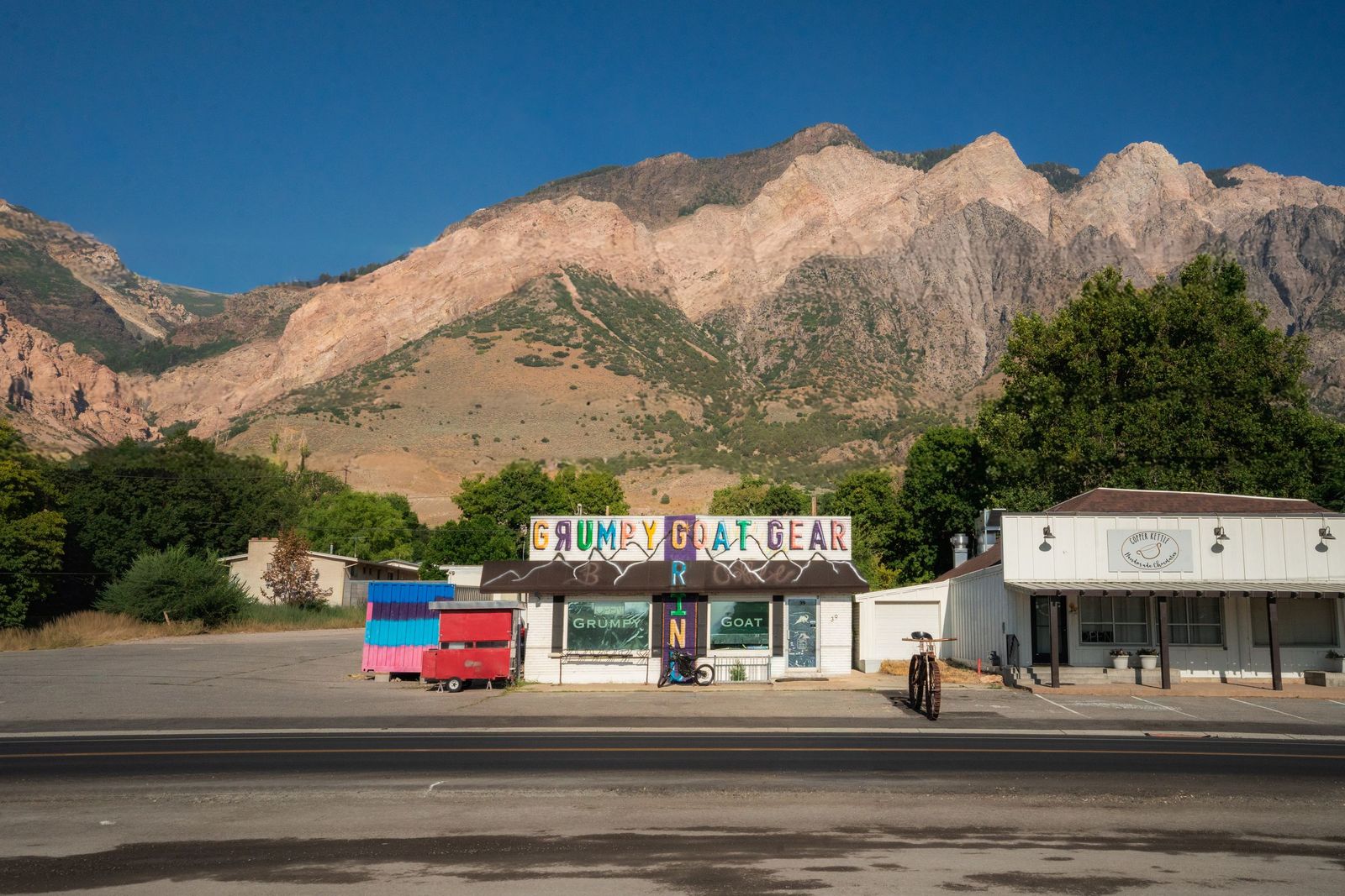 Grumpy Goat storefront on Main Street with the Wasatch mountains behind it